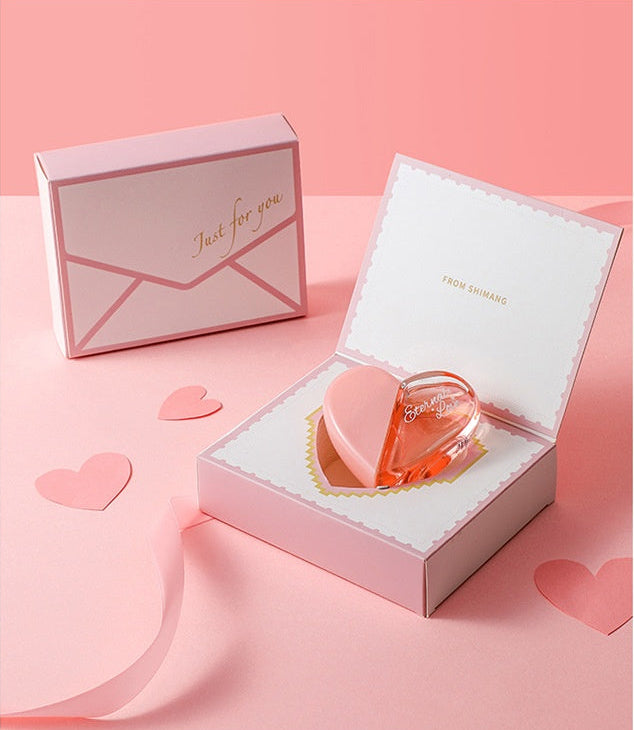 Heart-shaped pink box with a heart-shaped object inside on a pink background