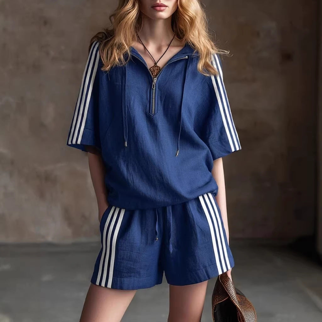 Woman wearing a blue outfit with white stripes against a neutral background
