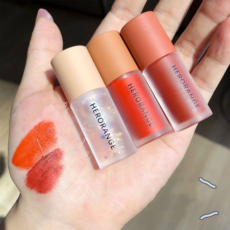 Four Herorange lipsticks on a hand with swatches of color.