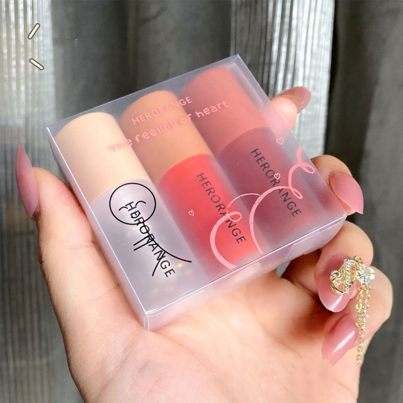 Hand holding a set of Heroine Rouge lipsticks in a clear case.