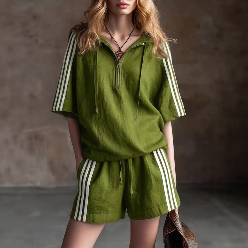 Person wearing a green outfit with white stripes in a neutral setting
