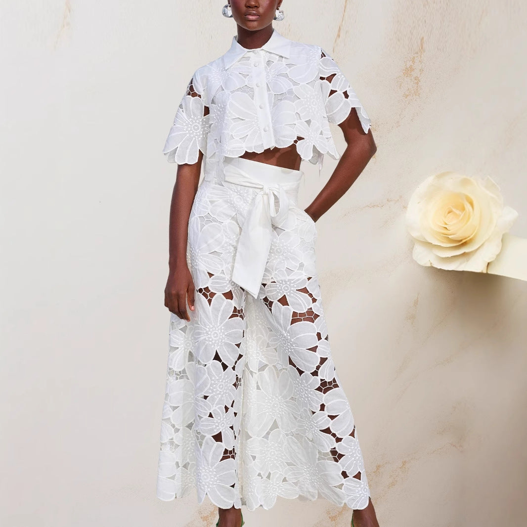 Woman wearing a white lace outfit with a beige background and a white flower.