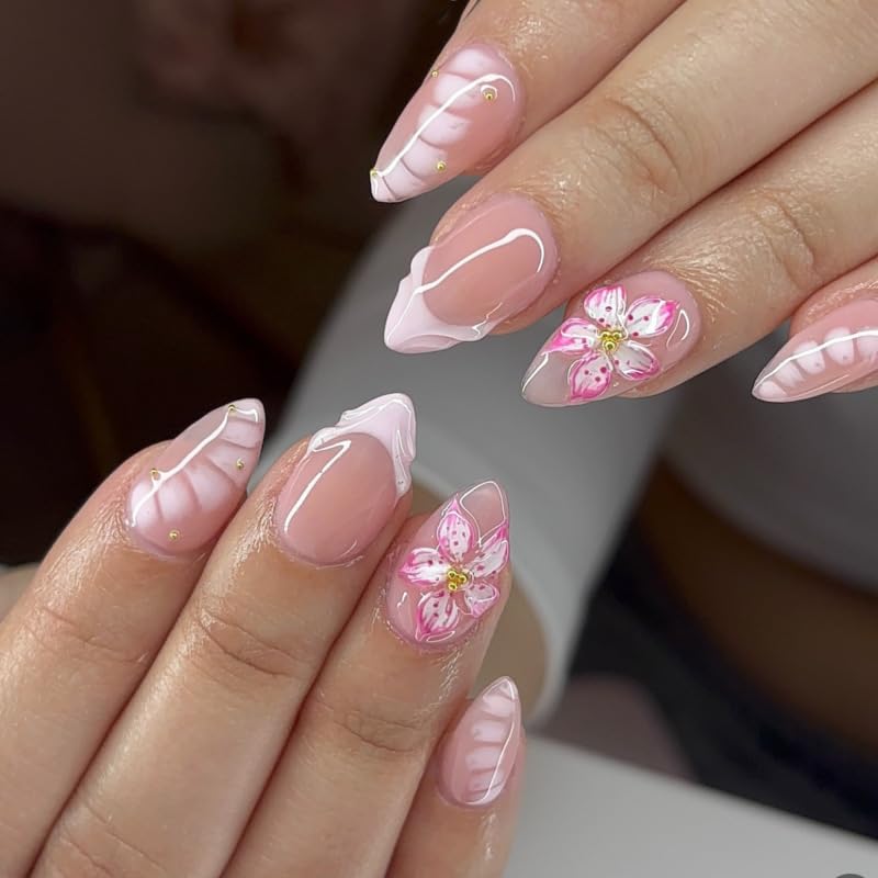Close-up of hands with pink floral nail art on a blurred background