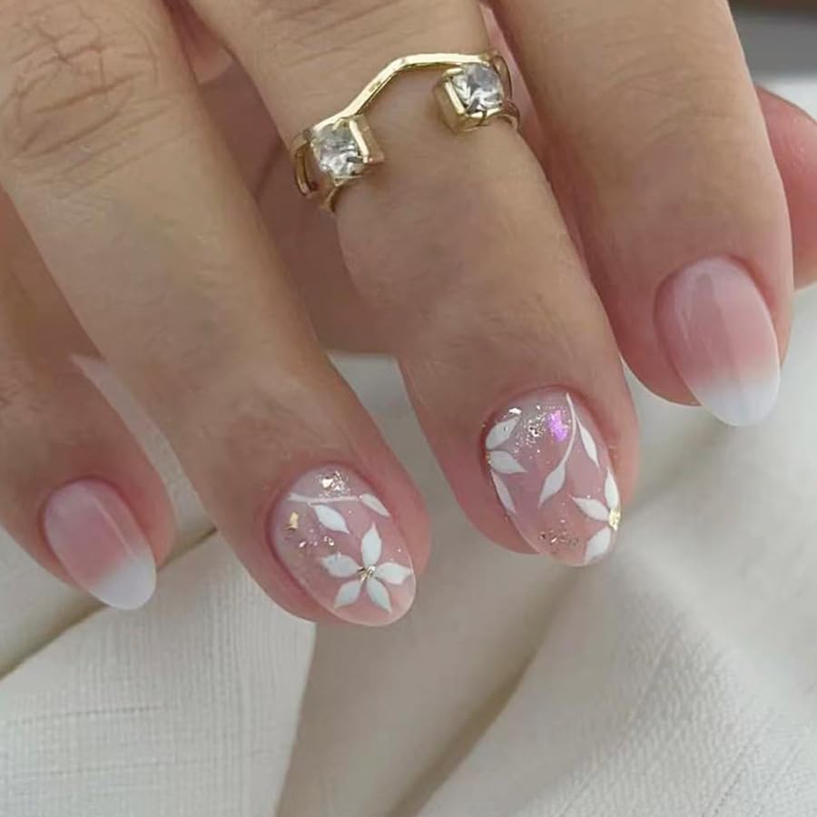 Close-up of a hand with decorative nails and a gold ring on a light background