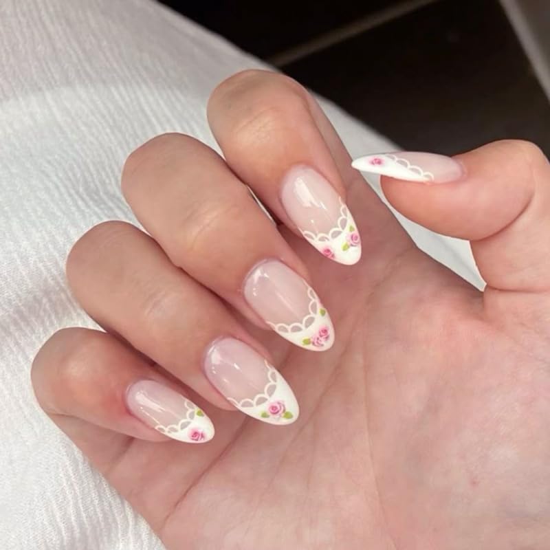 Hand with decorative nail art featuring floral designs on a white background