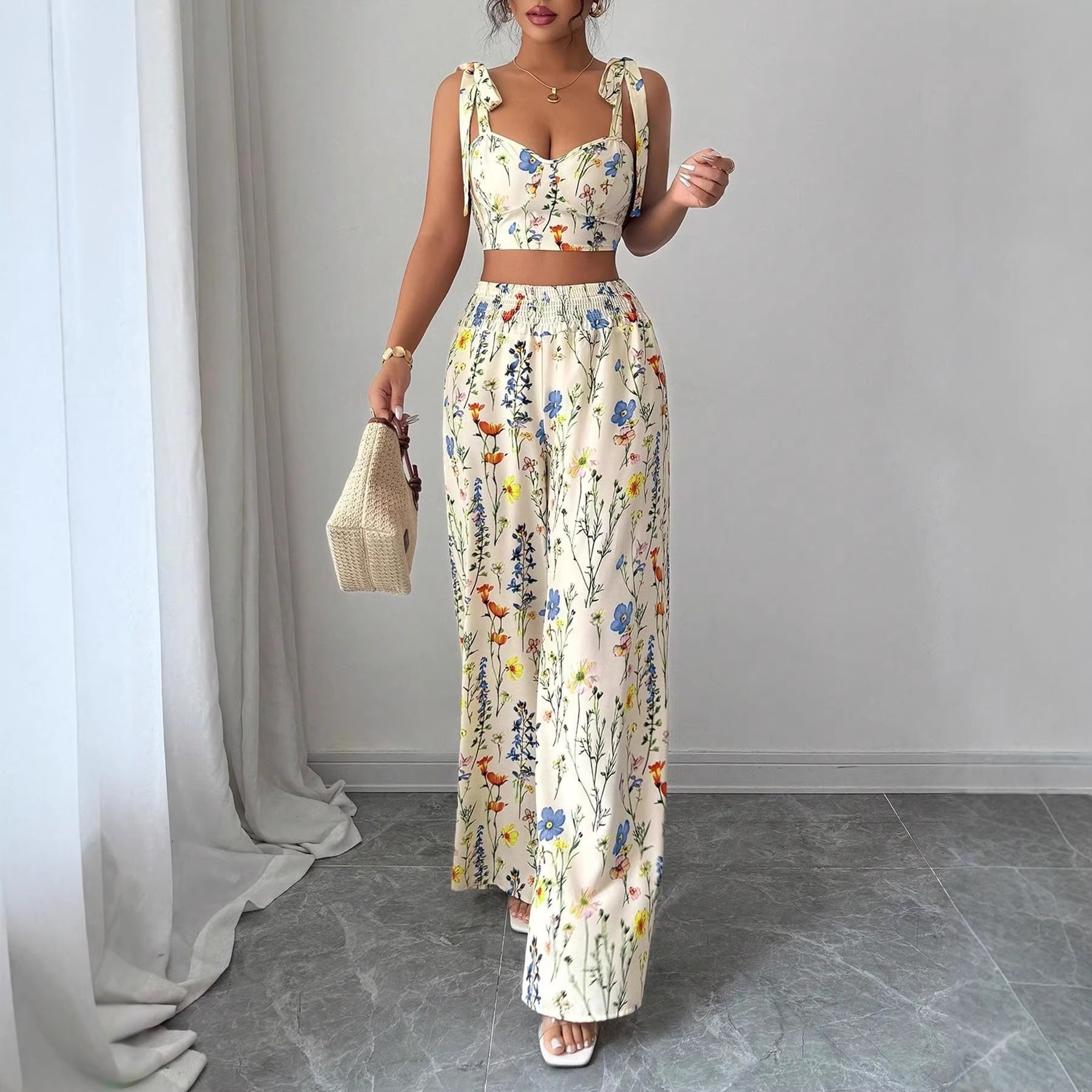Woman wearing a floral dress standing in a room with gray walls and a gray floor.
