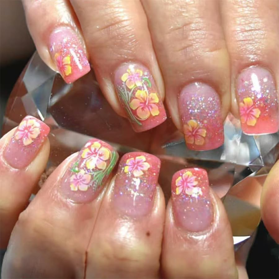Nails with pink and floral design held by a hand