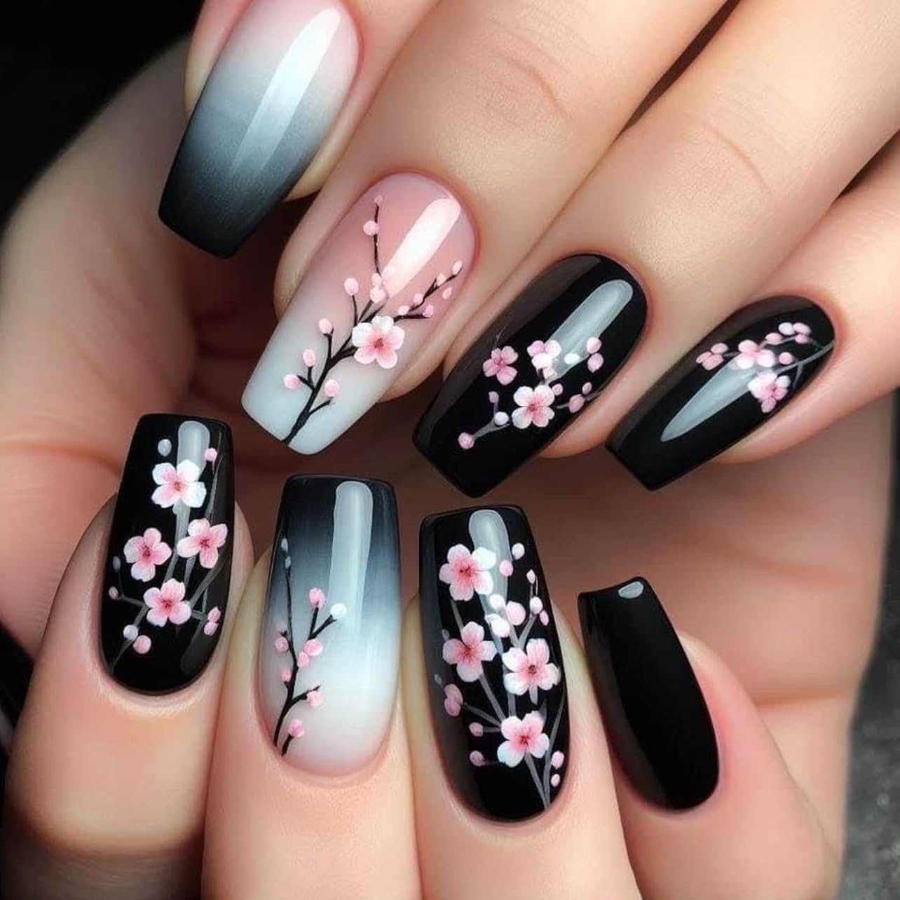 Nails with black, white, and pink floral design on a hand