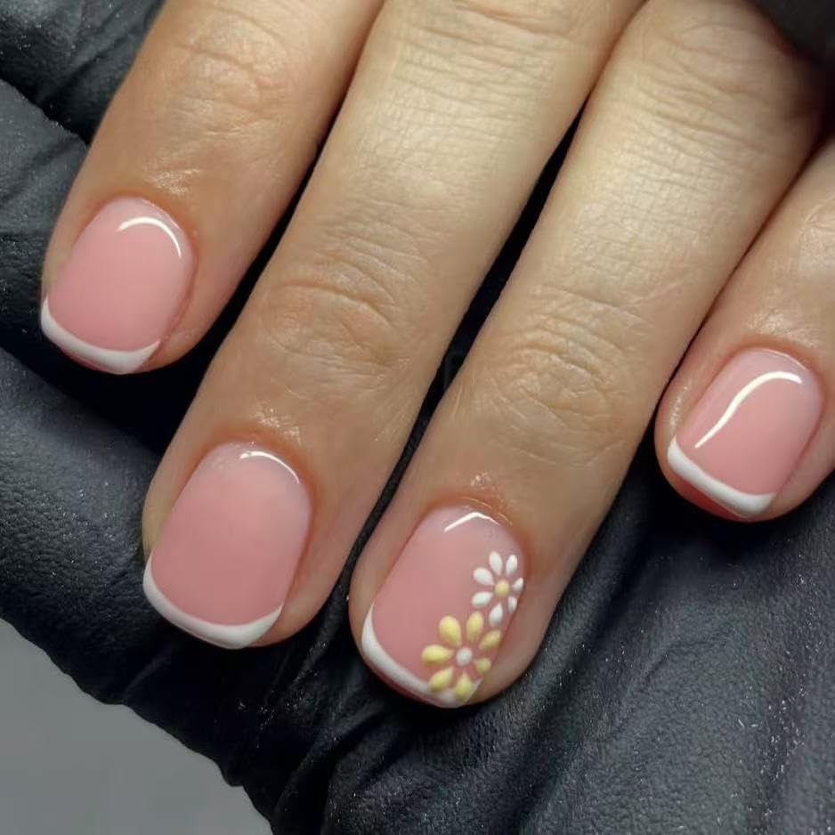 Close-up of a hand with pink nails and a floral design on a dark background