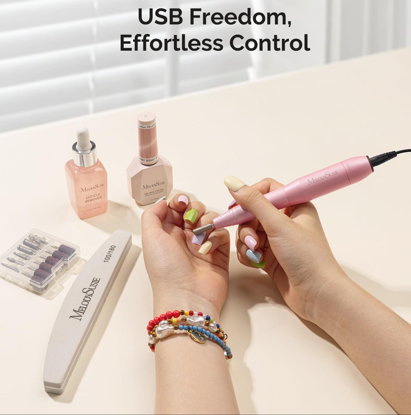 Person using a nail drill with Melodiusue products on a light surface.