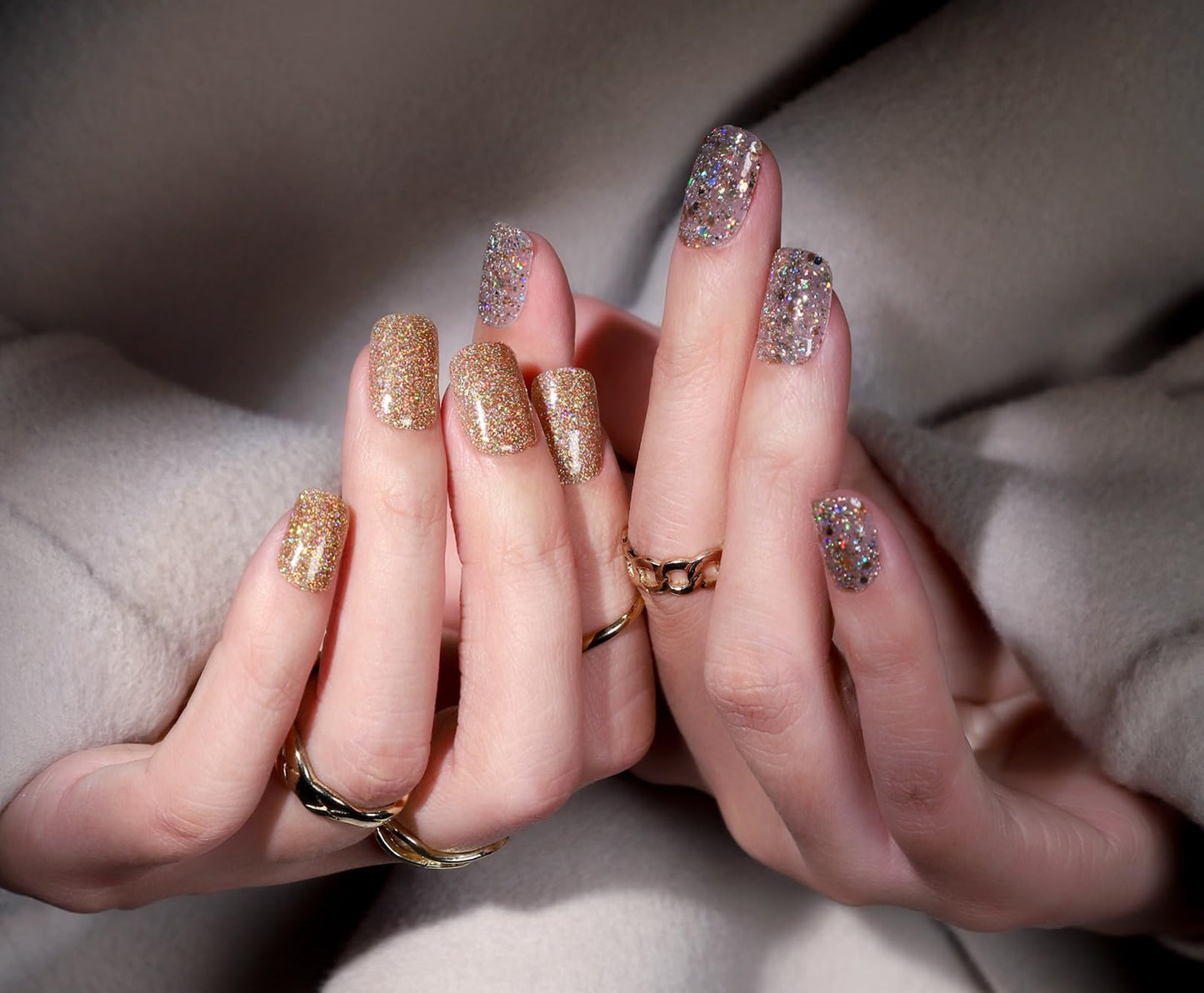 Close-up of hands with glittery nail polish and rings, featuring the brand 'Fandamei'.