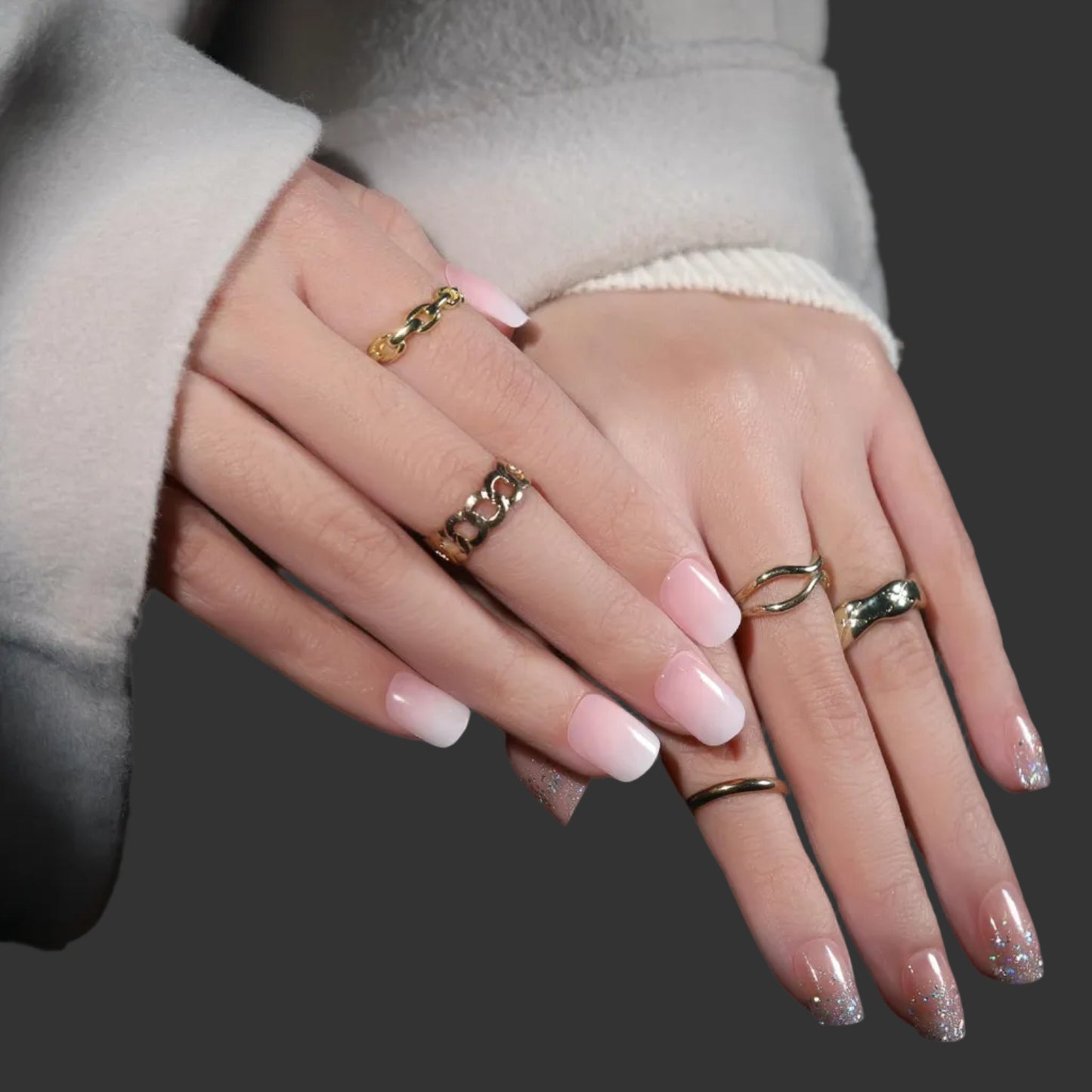Close-up of hands with pink nail polish and gold rings