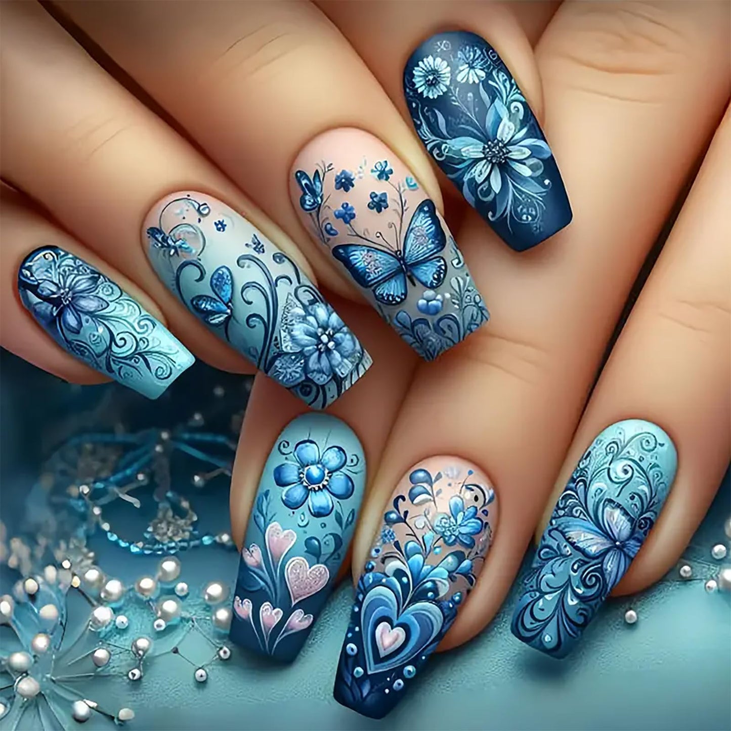 Nails with blue floral and butterfly designs on a light blue background
