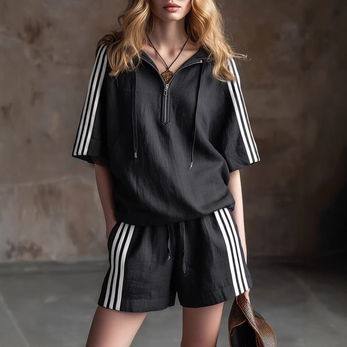 Person wearing a black outfit with white stripes in a dimly lit room.
