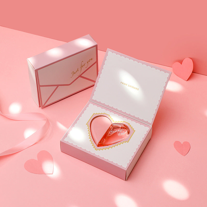 Heart-shaped product in an open box with a pink background